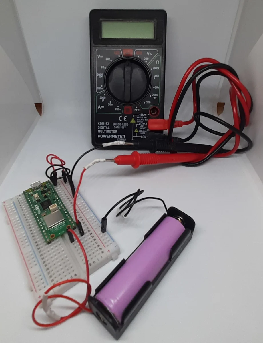 Raspberry Pi Pico 2 W power consumption test setup using a digital multimeter and 18650 battery