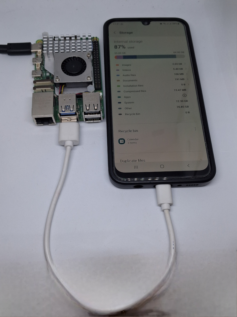 A Raspberry Pi 4 connected via white USB cable to a Samsung Galaxy smartphone showing the Android internal storage screen